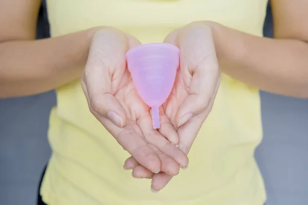 Femme inconnue tient une tasse hygiénique sur sa paume — Photo