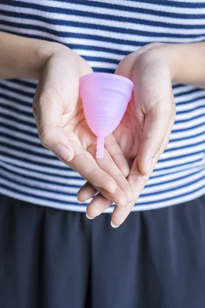 Jonge vrouw houdt een menstruatiecup op haar handpalm — Stockfoto