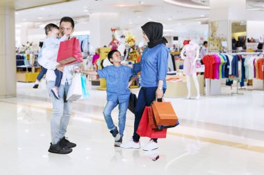 Aile, alışveriş merkezindeki boş vakitlerin tadını çıkarıyor.
