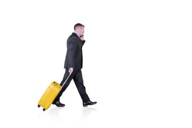 Stüdyoda telefonu ve bavulu olan bir erkek müdür.