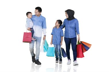 Müslüman aile alışverişten sonra birlikte yürüyor.