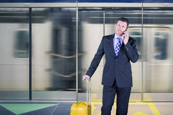 Obchodník mluví po telefonu na vlakovém nádraží — Stock fotografie