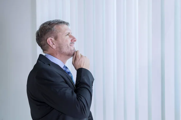 Empresario pensando en algo cerca de la ventana — Foto de Stock