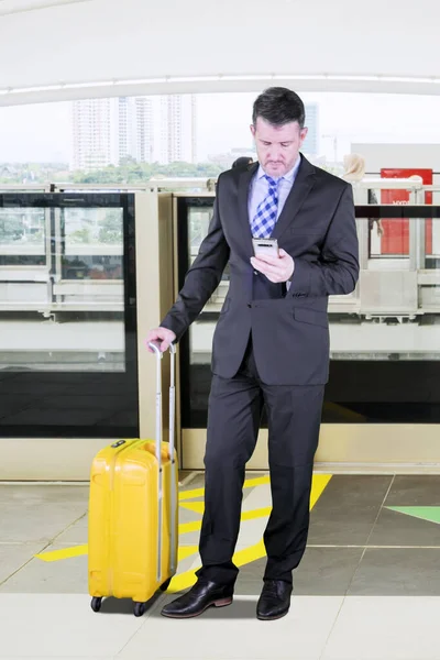 Obchodník s telefonem a zavazadly na vlakovém nádraží — Stock fotografie