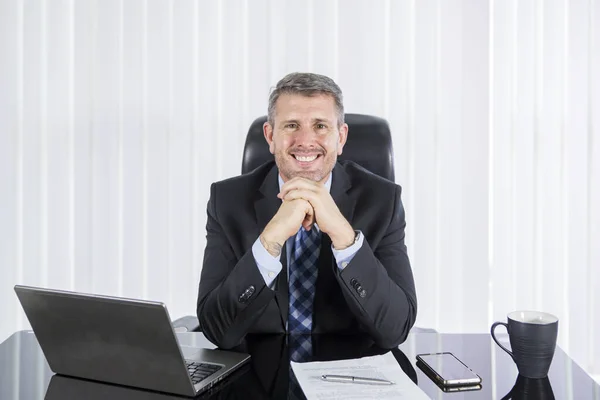 Homem de negócios caucasiano sorrindo para a câmera no escritório — Fotografia de Stock