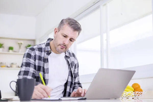 Kaukasier arbeitet mit Laptop und Klemmbrett — Stockfoto