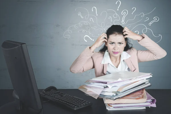 Confused businesswoman with pile of documents — Stock Photo, Image