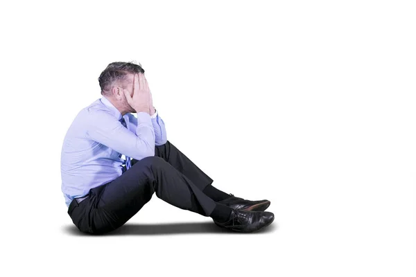 Depressed businessman sitting on the studio — Stock Photo, Image