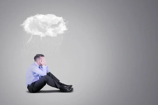 Depressed businessman with thunderstorm cloud