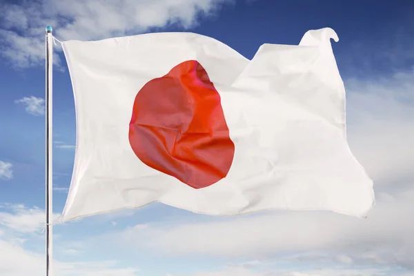 Japonská vlajka vlnící se pod modrou oblohou — Stock fotografie