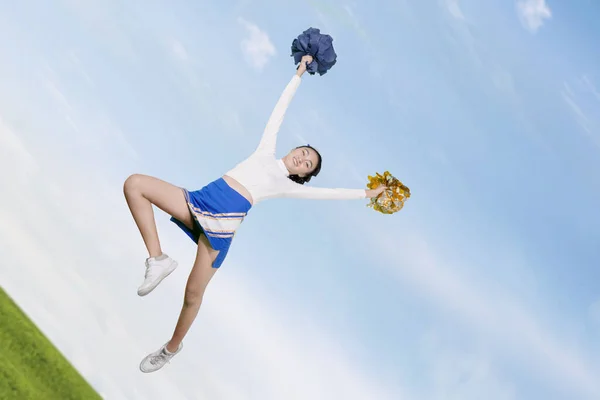 Visão de ângulo baixo da menina cheerleader dançando no parque — Fotografia de Stock