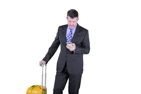 Male manager with phone and luggage on studio — Stock Photo, Image