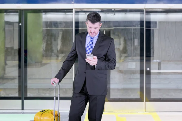 Gerente con teléfono y equipaje en la estación de tren — Foto de Stock