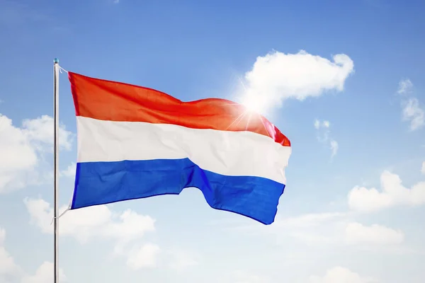 Netherlands national flag waving under blue sky — Stock Photo, Image