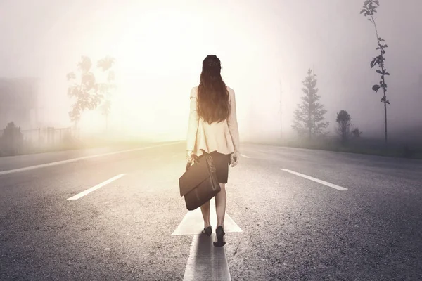 Вид ззаду бізнес-леді, що йде туманною дорогою — стокове фото