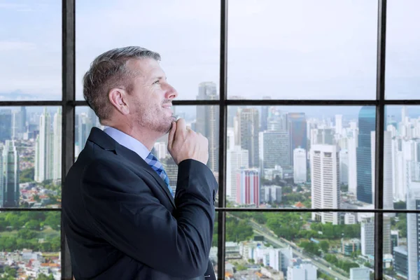 Vista lateral del hombre de negocios pensando cerca de la ventana — Foto de Stock