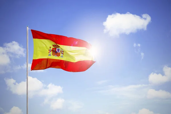 Испанский национальный флаг, размахивающий под голубым небом — стоковое фото