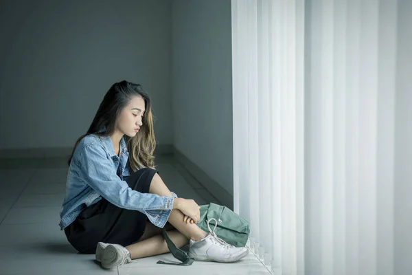 Дівчина-підліток виглядає пригніченою біля вікна — стокове фото