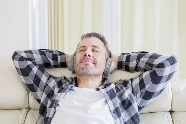 Jeune homme appréciant la musique avec écouteurs — Photo