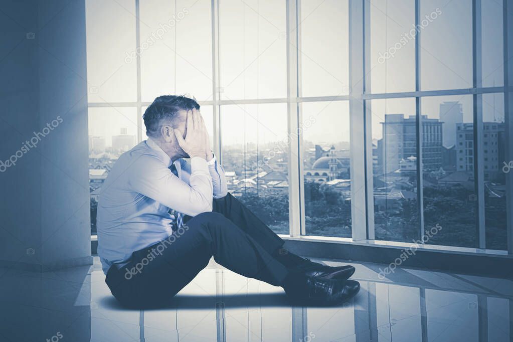 Depressed businessman sitting near the window