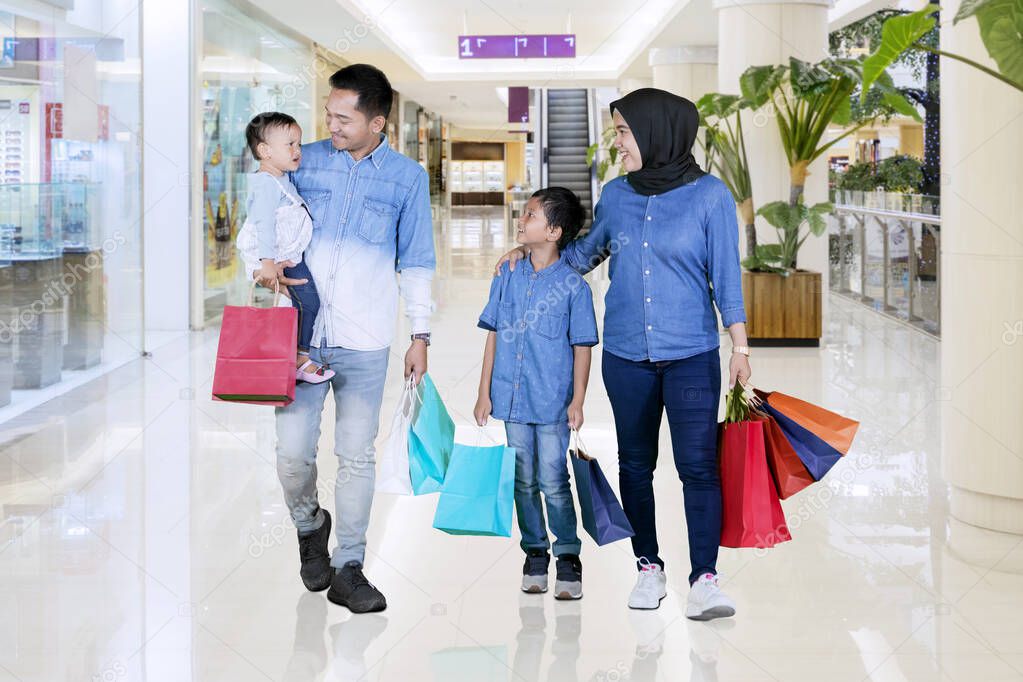 Muslim family walks together after shopping in mall