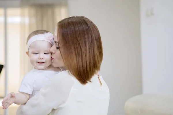 Liebevolle Mutter küsst ihr süßes Baby zu Hause — Stockfoto