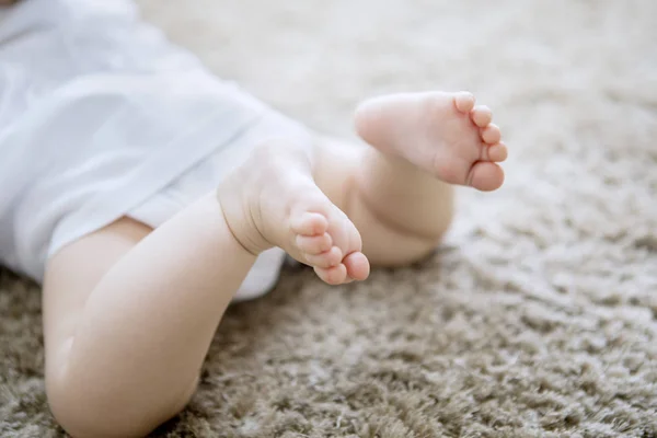 Blurred background of newborn baby feet on carpet — Stock Photo, Image