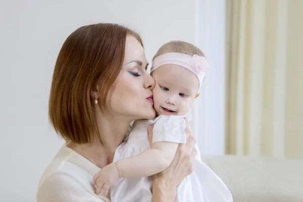Femme blanche embrassant sa joue de bébé à la maison — Photo