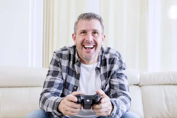 Homem alegre jogando videogames em casa — Fotografia de Stock