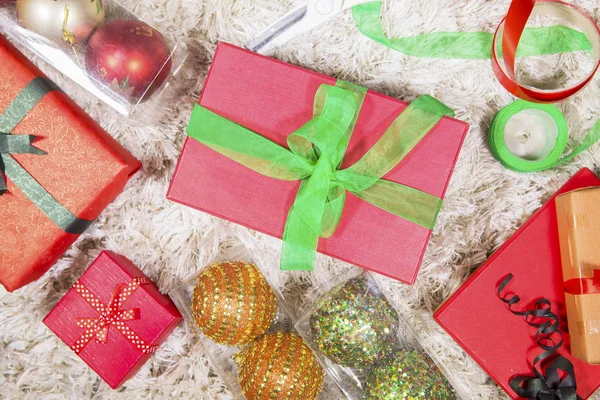 Karácsonyi ajándékok és díszek a szőnyegen — Stock Fotó