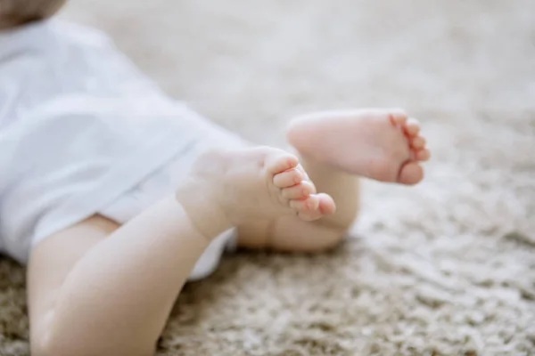 毛むくじゃらのカーペットの上でかわいい赤ちゃんの足のクローズアップ — ストック写真