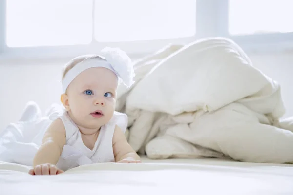 Schattig baby meisje kruipen op het bed — Stockfoto