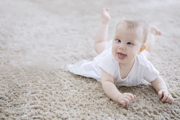 Cute baby girl creeping on the fur carpet — Stock Photo, Image