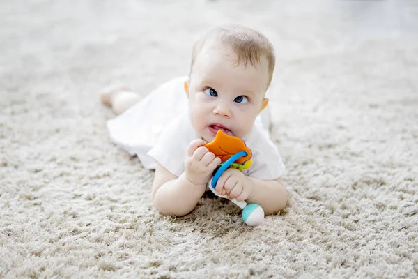 Милая девочка, играющая с игрушками на ковре из меха — стоковое фото