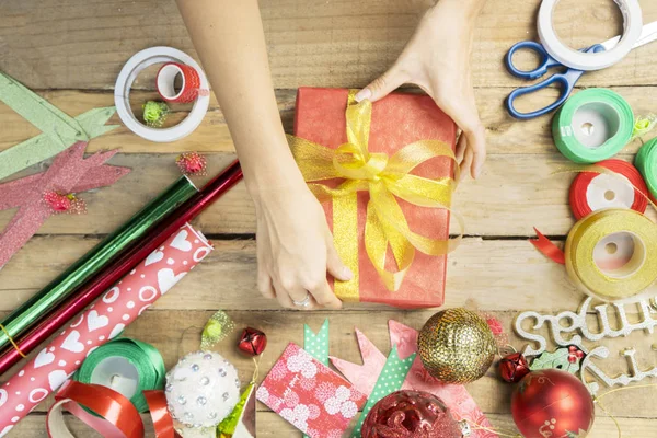 Vrouwelijke handen versieren een kerstcadeau met lint — Stockfoto