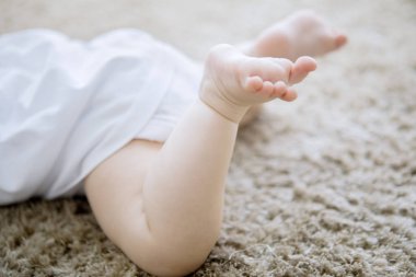 Tüylü halıda yeni doğmuş bebek ayakları