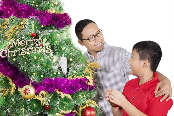 Ευτυχισμένος άνθρωπος στολίζει ένα χριστουγεννιάτικο δέντρο με το γιο του — Φωτογραφία Αρχείου