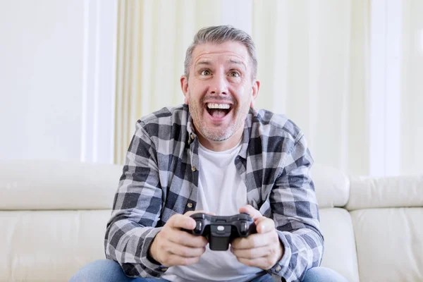 Счастливый человек играет дома в видеоигры — стоковое фото