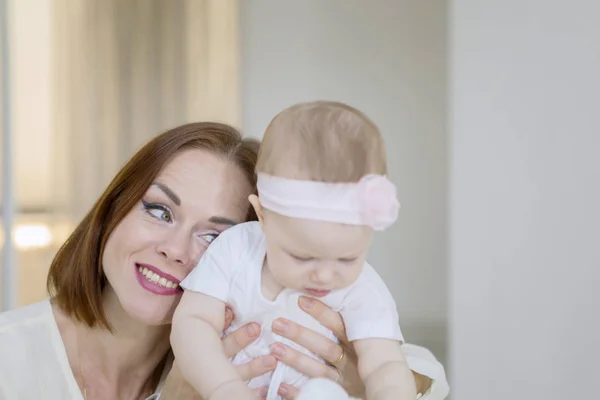 Lycklig mor omfamnar sin flicka bebis hemma — Stockfoto