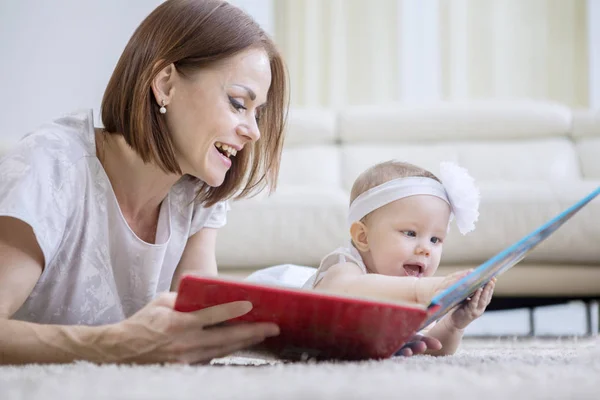 Mother and baby playing with a story book — Stock Photo, Image