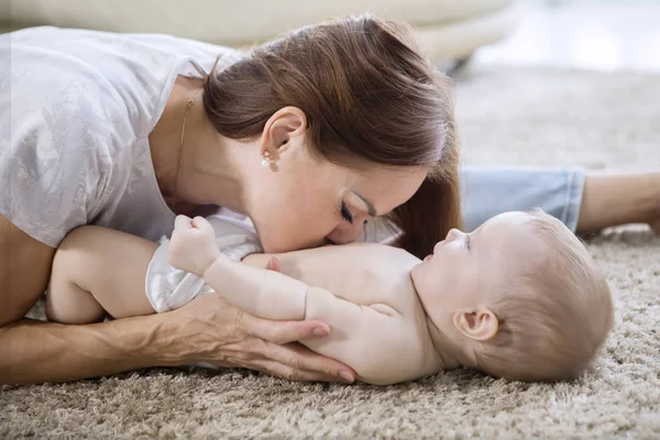 Mother kissing belly of her baby girl at home — Stock Photo, Image