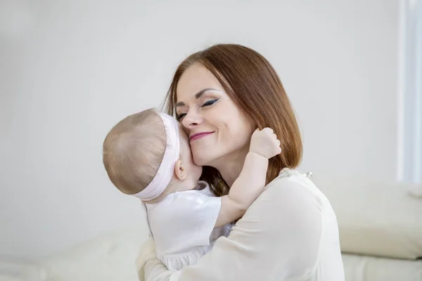 Mutter sieht glücklich aus, während sie ihr Baby umarmt — Stockfoto