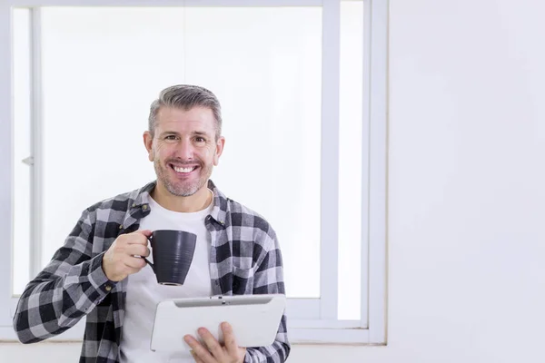 Usmívající se muž drží šálek kávy a tablet — Stock fotografie