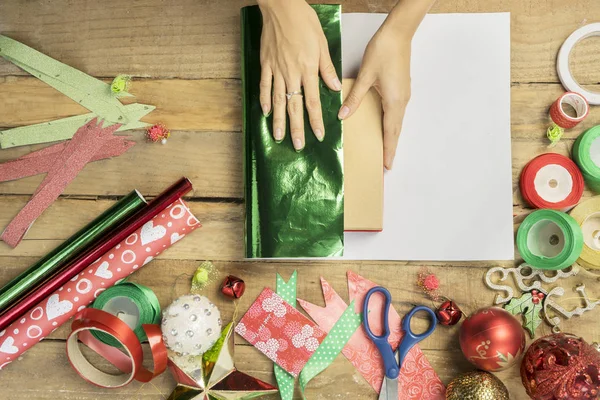 Mãos femininas desconhecidas embalando um presente de Natal — Fotografia de Stock