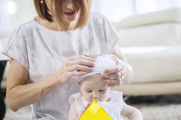 Žena dává čelenku na její roztomilé dítě — Stock fotografie