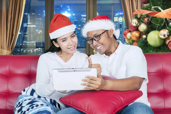 Casal jovem com polegar e tablet no Natal — Fotografia de Stock