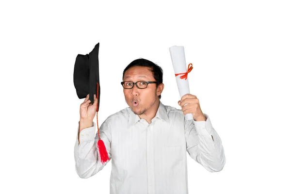 卒業を祝う幸せな男は スタジオに立っている間に卒業キャップと卒業証書を保持することによって 白地に隔離された — ストック写真