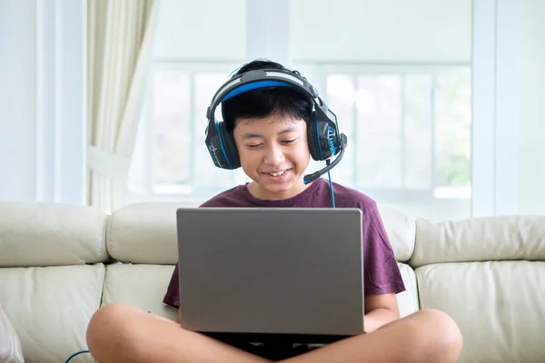 Niño Preadolescente Feliz Mientras Utiliza Ordenador Portátil Auriculares Sofá Casa —  Fotos de Stock