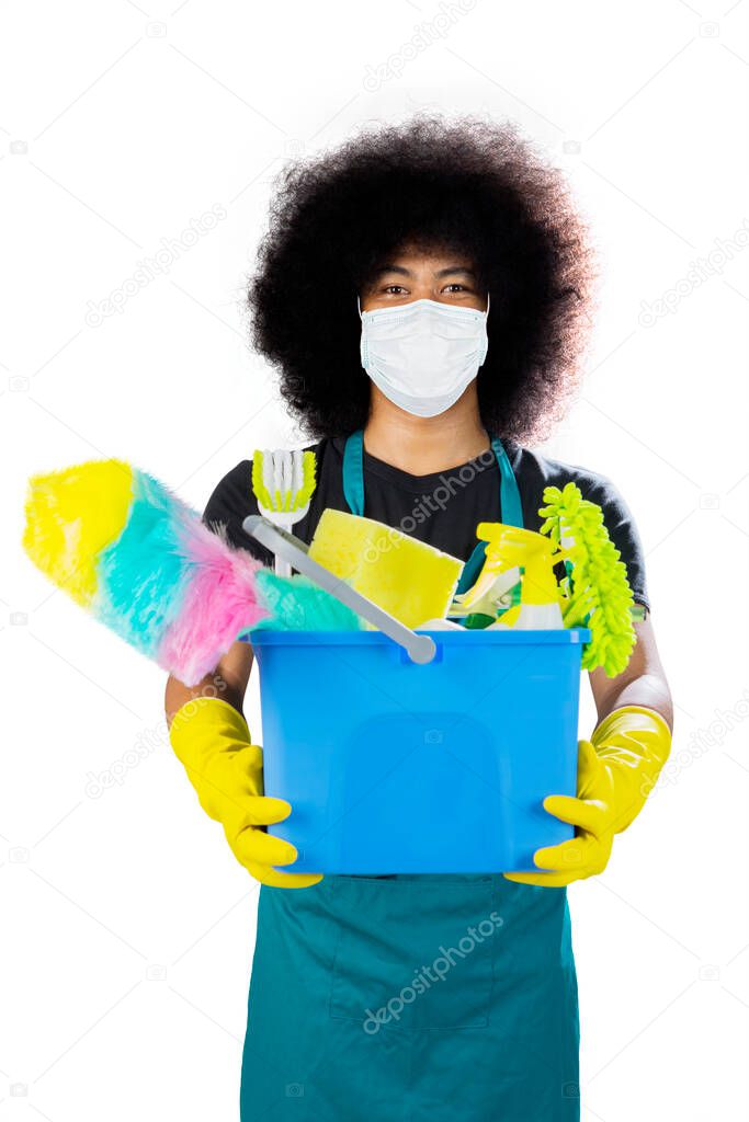 Male janitor wearing a mask to prevention coronavirus while holding cleaning items on the bucket, isolated on white background