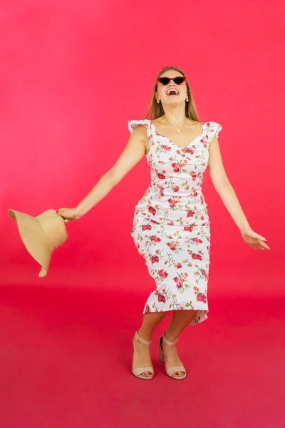 Счастливая Блондинка Прыгает Студии Солнечных Очках Летнем Платье Красном Фоне — стоковое фото